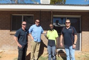 From left to right: Carey Joy from QP Plumbing, John McBryde from Central Australian Affordable Housing, Stephen Booth (with keys to his new home) and Kevin Skinner, Anglicare NT Case Support Worker.